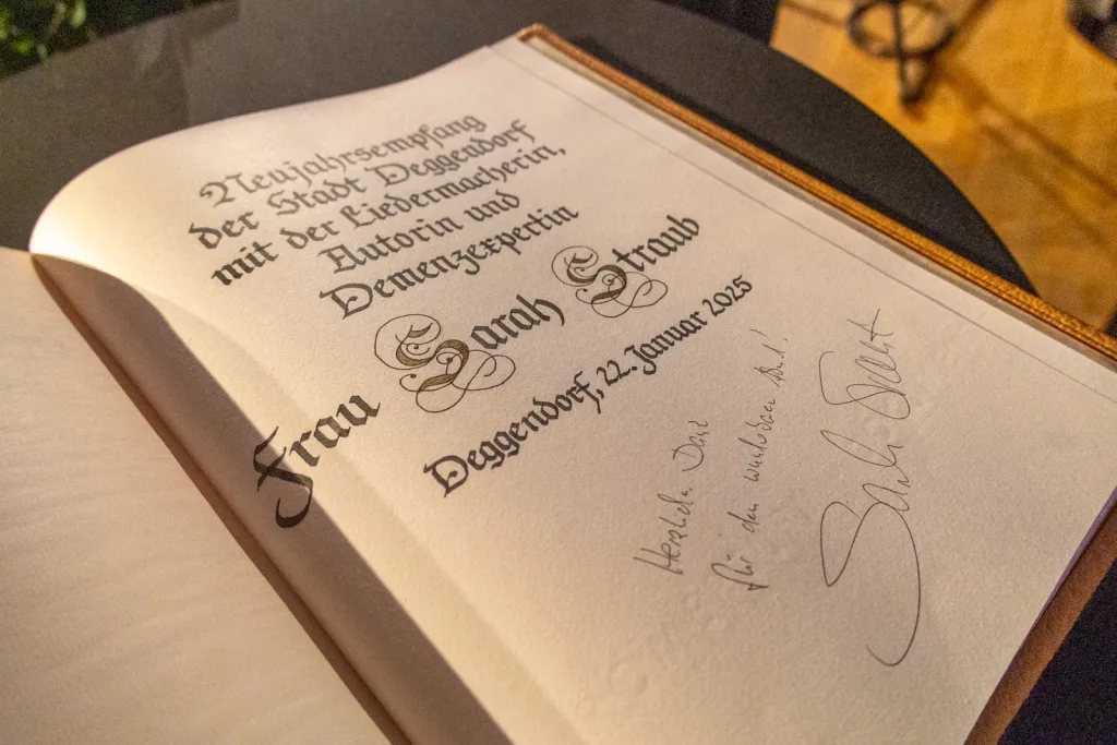 Aufgeschlagenes Gästebuch mit einer handschriftlichen Widmung zum Neujahrsempfang 2025 auf einem Tisch