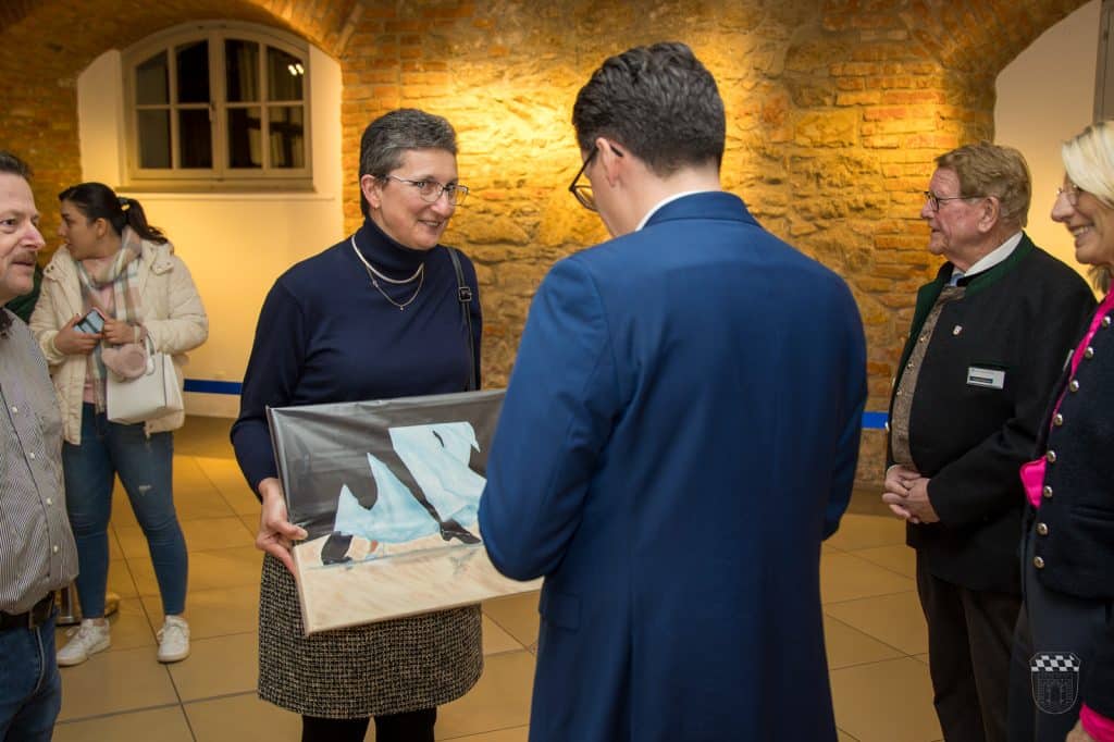 Ausstellung: Geschenküberreichung mit Personen