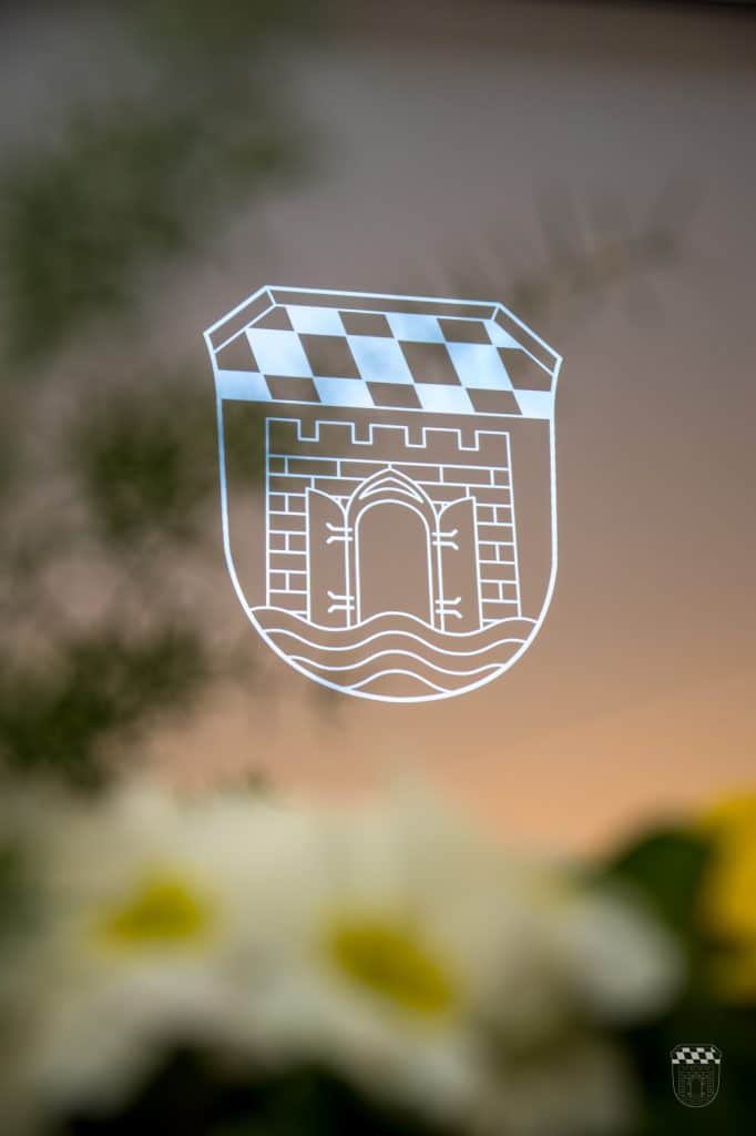 Wappen mit Burg und kariertem Muster