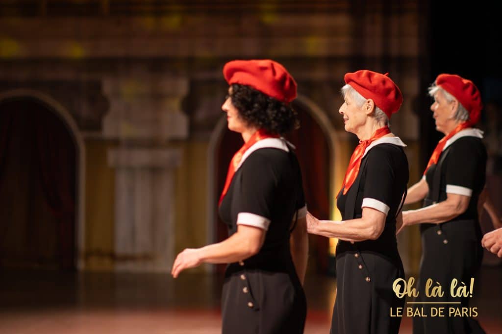 Frauen in roten Baskenmützen tanzen